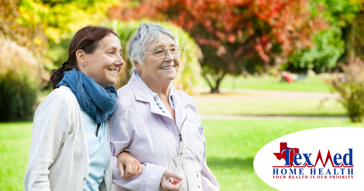 A recently retired woman enjoys her caregiving job as she walks with a senior client outside.