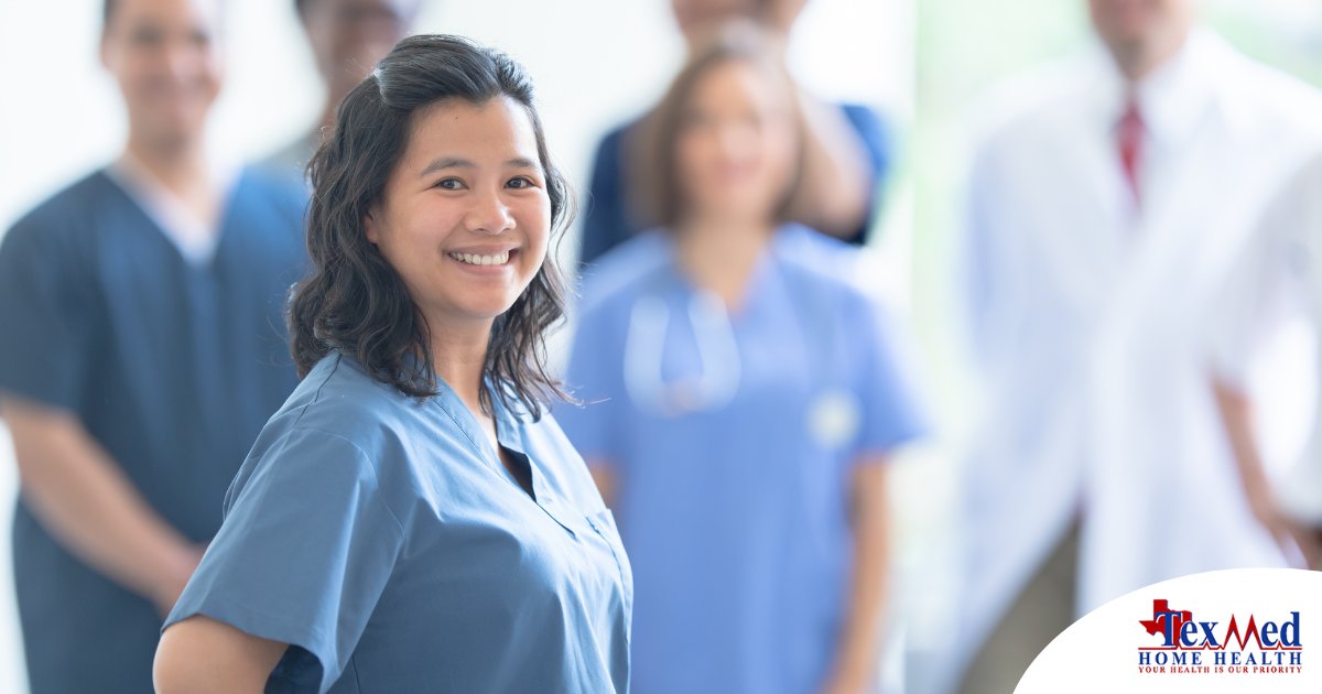 A woman in scrubs smiles with a team behind her, representing the joy that can come from a career as an OT, as Occupational Therapy Month promotes.