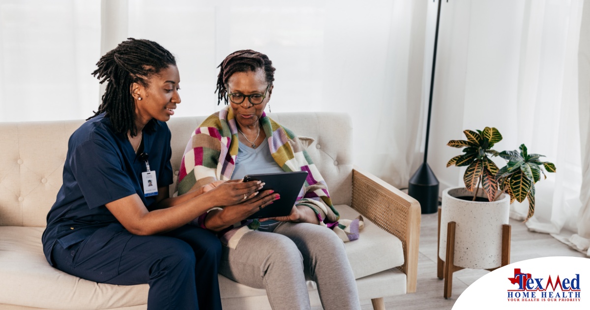 A caregiver talks with a patient while showing her information on a tablet representing the type of thorough communication needed for effective and professional care of home health care patients.