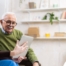 Home caregiver assisting senior man to use telehealth and senior care